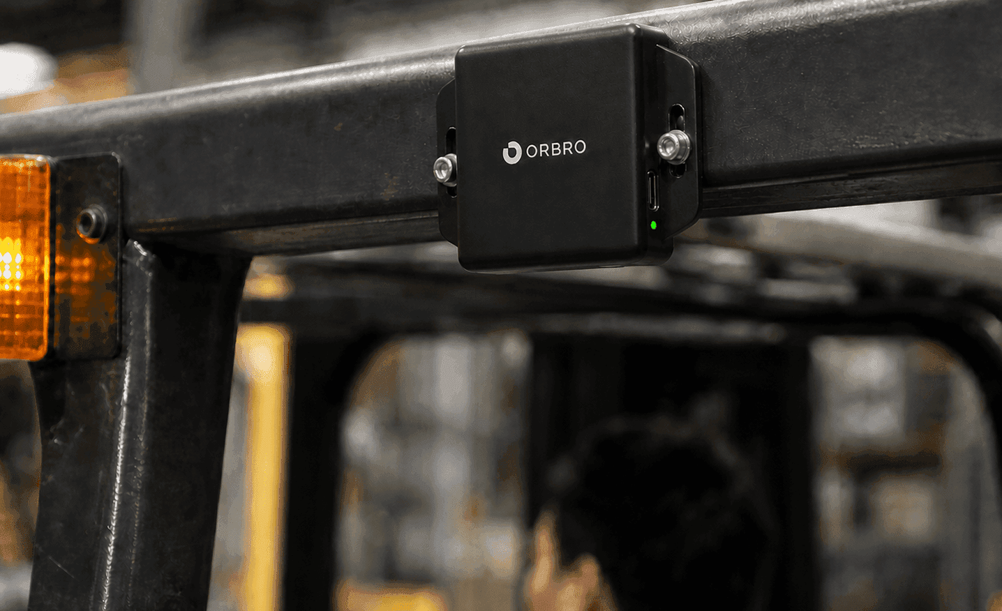 A UWB Tag RU-O3405 mounted at its actual scale in the center of a black forklift overhead guard